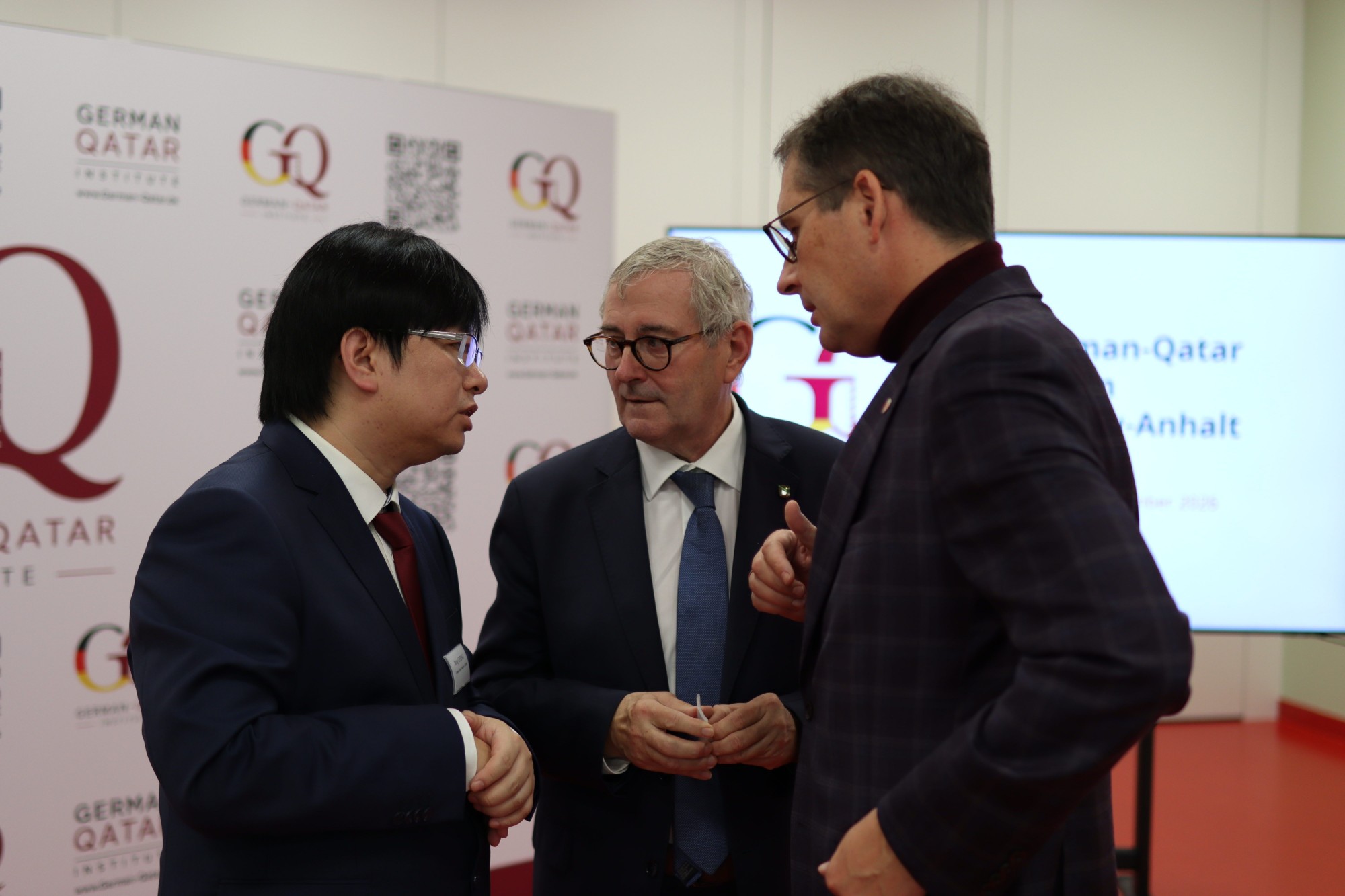 Ming Cheng im Gespräch mit Staatssekretär Dr. Jürgen Ude und Oberbürgermeister Dr. Alexander Vogt beim German-Qatar Forum Sachsen-Anhalt in Halle (Saale)